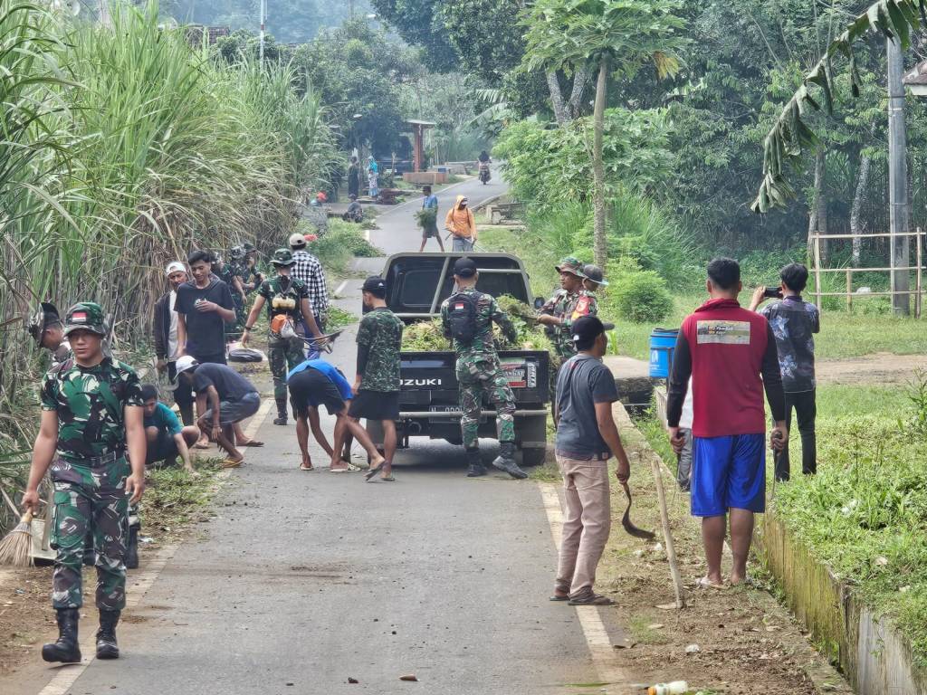 Babinsa Wonokoyo dan Warga Bersinergi Membersihkan Saluran Air dan Rumput Poros Jalan Utama